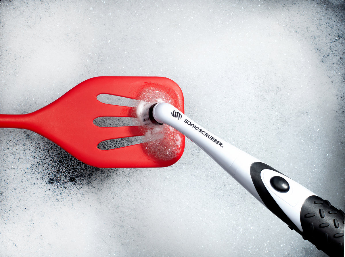 SonicScrubber cleaning a red spatula